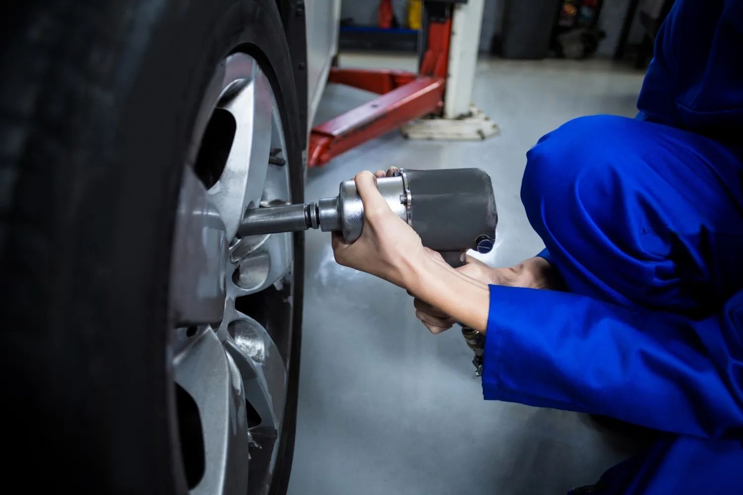 hands-female-mechanic-fixing-car-wheel-with-pneumatic-wrench(Custom)