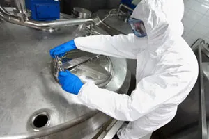 man-in-a-white-suit-at-a-chemical-container