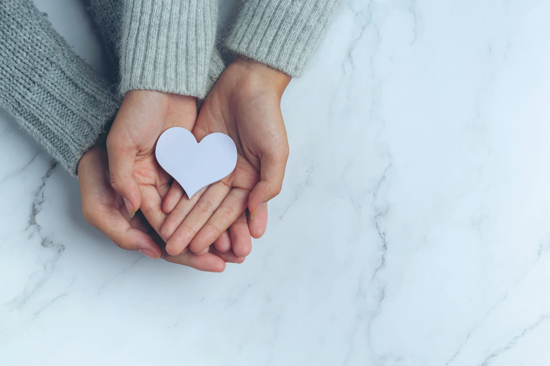 paper-heart-put-couple-s-hands-marble-table