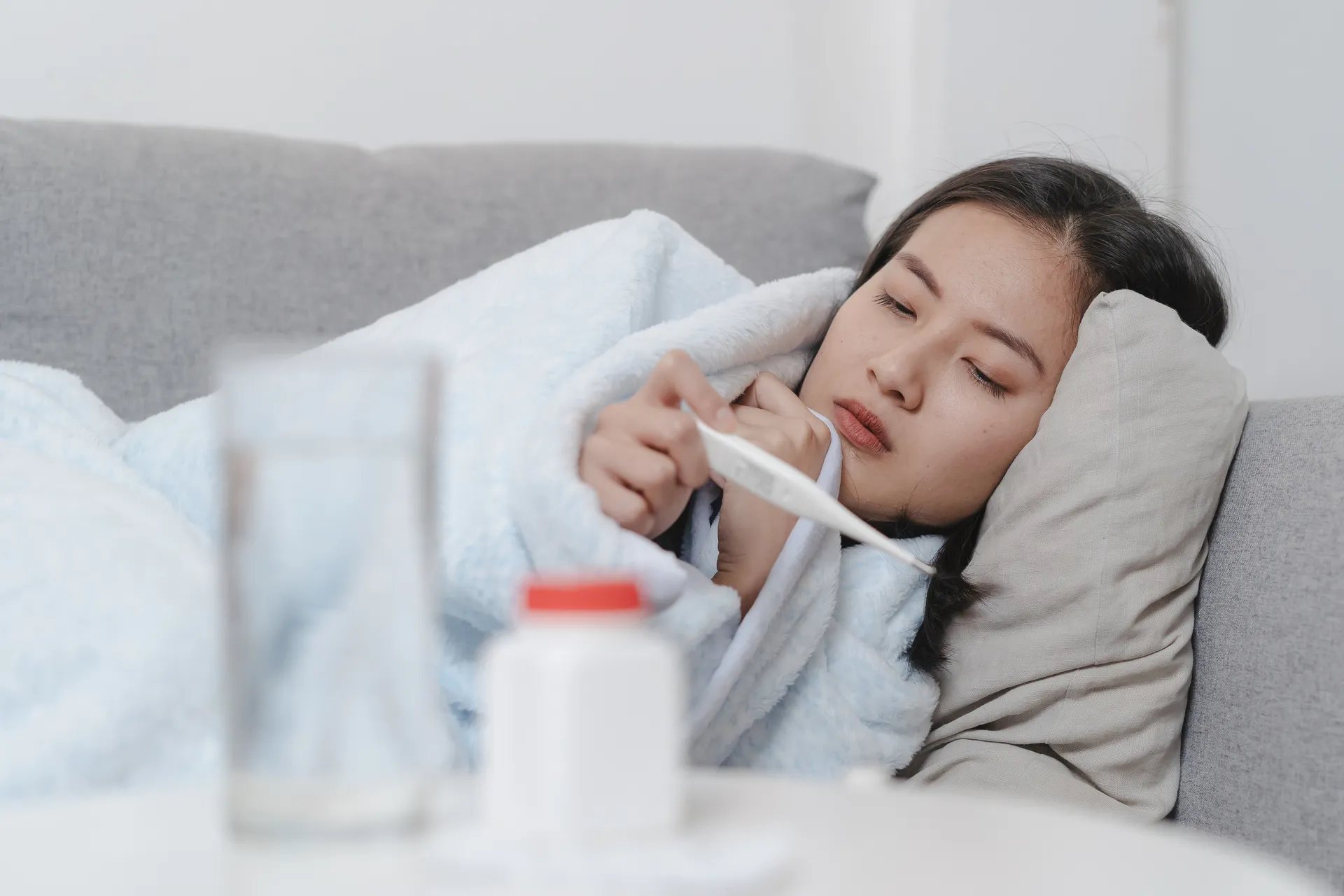 woman-measuring-temperature-her-body-bed-person-got-fever-lying-sofa