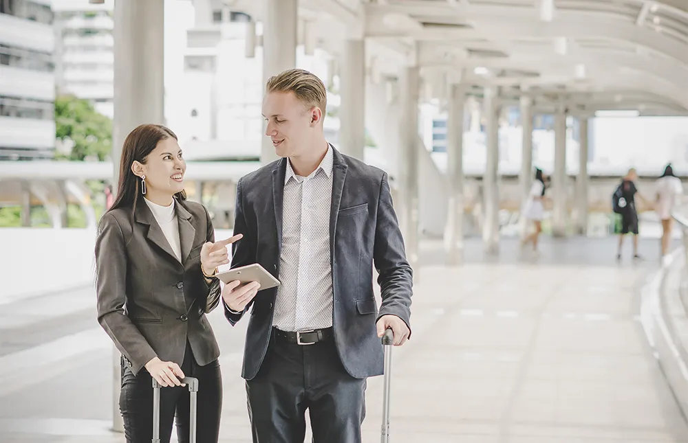 colleagues-using-digital-tablet-while-standing-footbridge