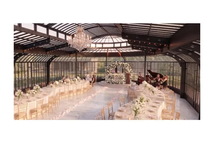 บรรยากาศการตกแต่งภายใน Glass House สำหรับงานเลี้ยงแต่งงาน พร้อมโต๊ะจัดเลี้ยงยาวและซุ้มดอกไม้ประดับ