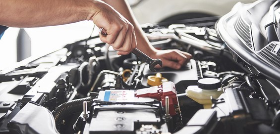 muscular-car-service-worker-repairing-vehicle