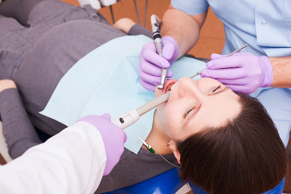 dentist-treats-teeth-with-help-dental-instruments-pregnant-patient