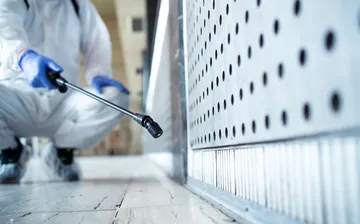 Cleaning-Services13357901568240002unrecognizable-person-white-chemical-protection-suit-doing-disinfection-public-ar