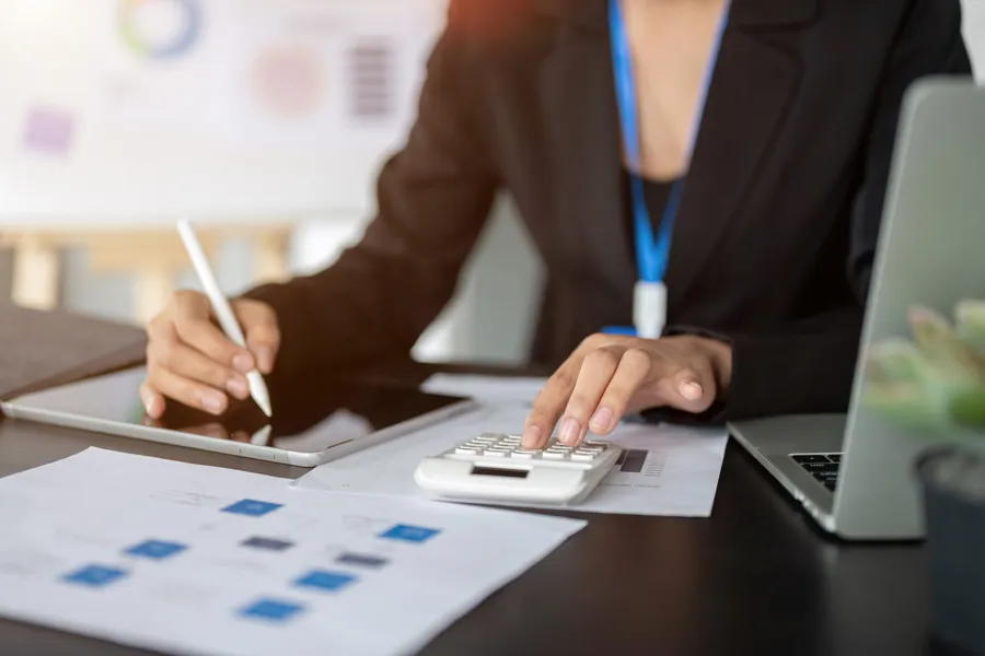 professional-female-accountant-working-her-desk-using-calculator-digital-tablet