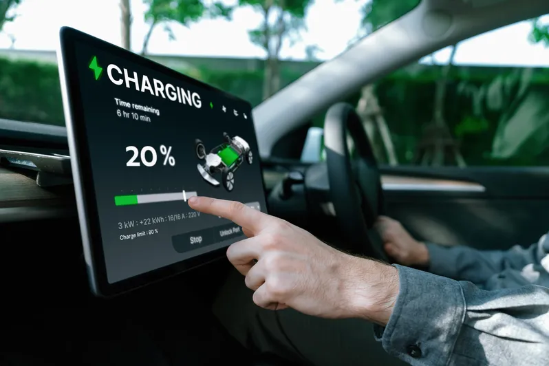 electric-car-driver-checks-battery-charging-status-app-screen-car-innards copy